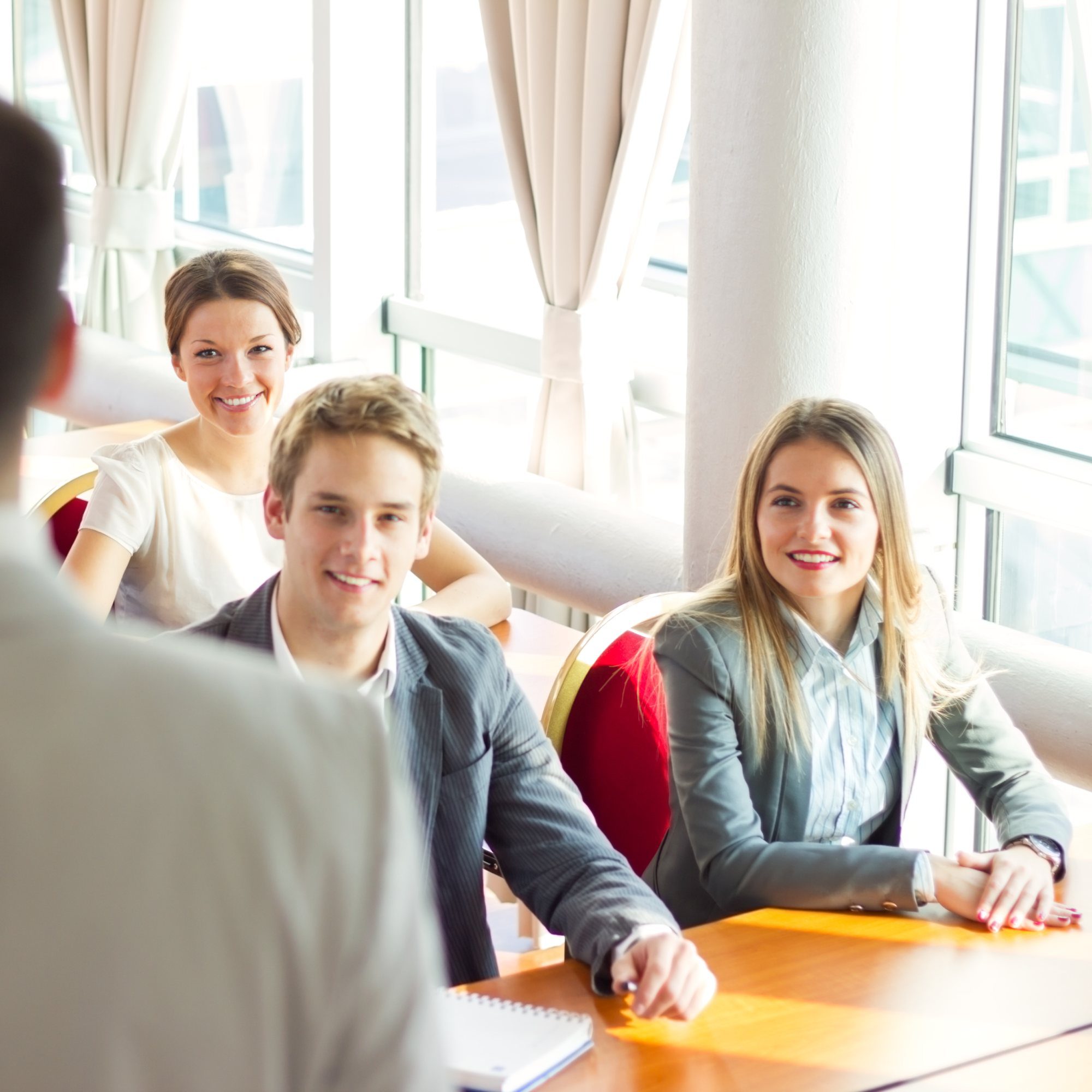 Business meeting with smiling participants at table.